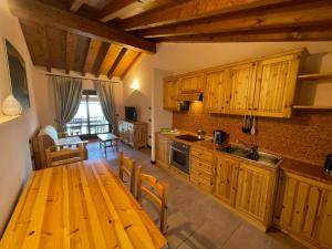 a kitchen with wooden cabinets and a wooden table at La FIOCCHINA - Magic Place - apartments & studios in Garda Lake - countryside farmhouse, inside the middle of the lake between sky & water in Salò