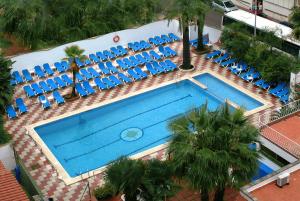 an overhead view of a swimming pool with blue chairs at Hotel Rosa Nàutica in Malgrat de Mar