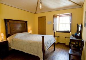 Un dormitorio con una cama grande y una ventana en SOLAR DAS ARCAS Manor House - Deluxe Mountain AP, en Arcas