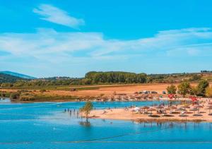 a beach with umbrellas and people on the sand and water at SOLAR DAS ARCAS Manor House in Podence
