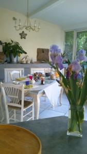 une table avec des fleurs violettes dans un vase sur une table dans l'établissement Chambres d'hôtes Lou Félibre, à Vic-la-Gardiole