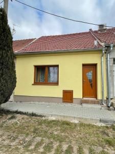 żółty dom z brązowymi drzwiami i oknami w obiekcie Ubytování Valtík w mieście Valtice