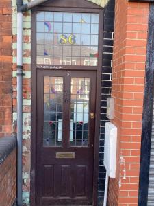 une porte en bois avec une fenêtre sur un bâtiment en briques dans l'établissement Headrose House, à West Bromwich