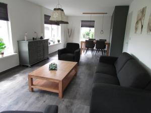 een woonkamer met een bank en een salontafel bij De Steerne, mooie plek aan het Overijssels kanaal. in Schalkhaar