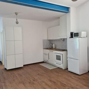 eine Küche mit weißen Schränken und einem weißen Kühlschrank in der Unterkunft Appartamento Ticino in Monte Carasso