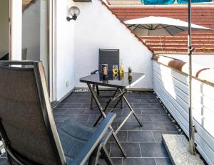 mały stolik na balkonie z parasolem w obiekcie Stylische 2-Zimmer Wohnung - Balkon - Parkplatz - Smart TV - Arbeitsplatz w mieście Friedberg