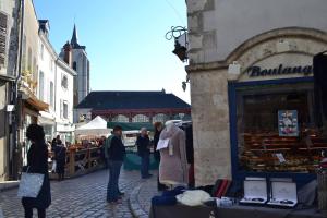 un grupo de personas caminando por una calle con un mercado en La talonnière, maison de village avec terrasse et 3 chambres, en Messas