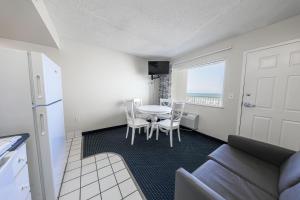 a living room with a couch and a table and chairs at Flamingo Hotel & Tower in Panama City Beach