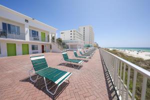 a row of chaise lounges on a walkway to the beach at Flamingo Hotel & Tower in Panama City Beach