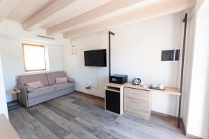 - un salon avec un canapé et une télévision dans l'établissement Tenuta Della Casa Wine & Rooms - La Pausa del Collio, à Cormòns