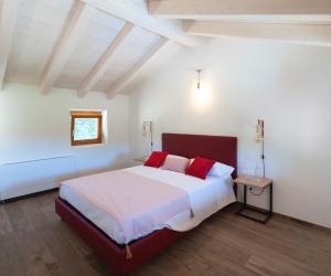 a bedroom with a large bed with red pillows at Tenuta Della Casa Wine & Rooms - La Pausa del Collio in Cormòns +29 photos