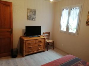 a bedroom with a television on top of a dresser at A LA JOIE DE VIVRE Chez l'habitant in Banat