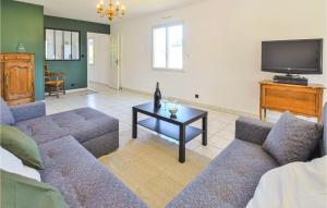 uma sala de estar com um sofá e uma televisão em Cozy Home In Sainte-mre-glise With Wifi em Sainte-Mère-Église