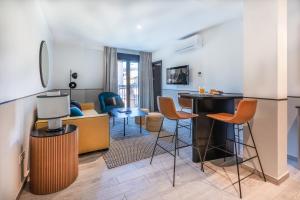 uma sala de estar com uma cozinha com mesa e cadeiras em Slow Suites Setas em Sevilha