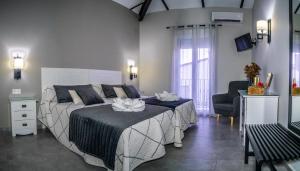 1 dormitorio con 1 cama grande y 1 silla en Apartamentos Turísticos El Altozano, en Fuentes de León