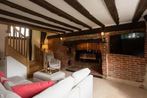 un soggiorno con camino in mattoni e divano bianco di Honeysuckle Cottage a Thornham Magna