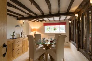 a dining room with a table and chairs at Honeysuckle Cottage in Thornham Magna