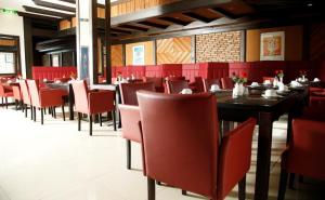 a dining room with red chairs and tables in a restaurant at Hotel Lorien in Cologne