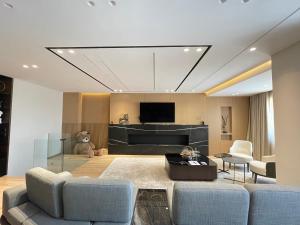 Luxury Lake View Duplex with Indoor Fireplace في شكودر: غرفة معيشة مع أريكة وتلفزيون