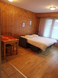 um quarto com uma cama e uma mesa em Hôtel des Bains d'Ovronnaz em Ovronnaz