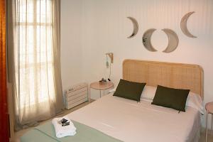 セビリアにあるApartamento Calle Feriaのベッドルーム(緑の枕が付く白いベッド付)