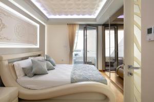 Schlafzimmer mit einem großen Bett und einem Fenster in der Unterkunft De President Suite, DeMaNi President Suites in Sitia