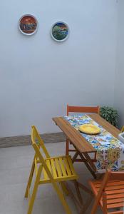 a wooden table with a chair and plates on the wall at InterMezzo - located in the center of Salento equidistant from the 2 seas in Scorrano
