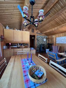una sala da pranzo e una cucina con tavolo e lampadario pendente. di Hjemmekoselig hytte med fantastisk utsikt a Beitostøl