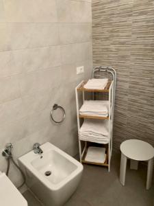 a bathroom with a sink and a shelf with towels at InterMezzo - located in the center of Salento equidistant from the 2 seas in Scorrano