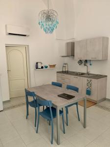 een keuken met een tafel en blauwe stoelen in een keuken bij InterMezzo - located in the center of Salento equidistant from the 2 seas in Scorrano