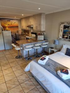 a room with two beds and a kitchen with a counter at Dolphins Self-Catering Accommodation in George