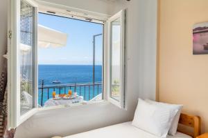 a bedroom with a window with a view of the ocean at Stafylos Rooms in Stafylos