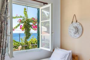a bedroom with a window with a view of the ocean at Stafylos Rooms in Stafylos