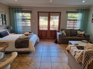 a living room with a bed and a couch at Dolphins Self-Catering Accommodation in George