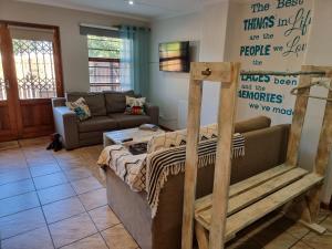 een woonkamer met een bed en een bank bij Dolphins Self-Catering Accommodation in George