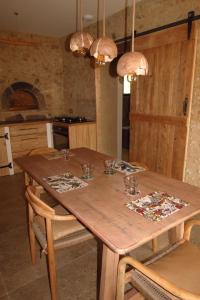einen Holztisch mit Gläsern darauf in der Küche in der Unterkunft Gîte écoconçu charmant proche zoo de la Flèche in Clermont-Créans