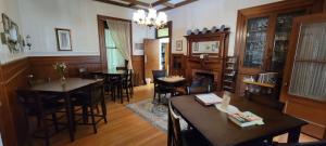 a living room with tables and chairs and a chandelier at Inn at the Agora in Lewiston