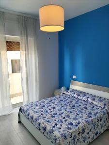 a blue bedroom with a bed with a blue wall at La casa di Lelè in Termoli