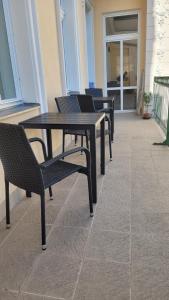 - une table et des chaises noires sur la terrasse dans l'établissement Apartmán U kolonády, à Mariánské Lázně