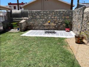 a picnic table in a yard next to a stone wall at Comfortable Suite with private entrance & private bathroom in El Paso