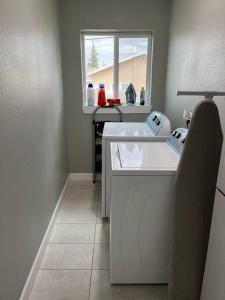 a white kitchen with a sink and a window at Comfortable Suite with private entrance & private bathroom in El Paso