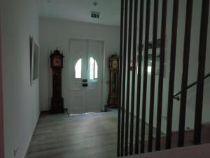 un corridoio con una porta e un orologio a pendolo di AL-Odeceixe Verde a Odeceixe