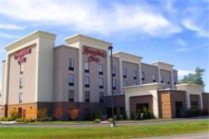 a large white building with red writing on it at Hampton Inn Oneonta in Oneonta