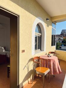 a patio with a table and chairs and a window at Tirana View Apartments in Tirana
