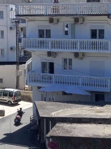 un edificio con balcones y una persona en un scooter delante en Accommodation Milla, en Ulcinj