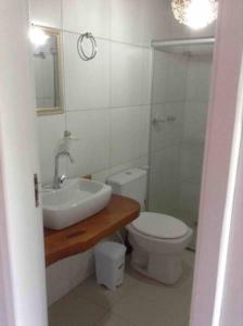 y baño con lavabo, aseo y espejo. en Flat Casagrande, en Morro de São Paulo