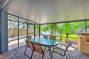 a screened in porch with a table and chairs at Lovely Palm Coast Retreat with Outdoor Kitchen in Palm Coast