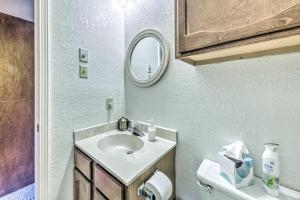 een badkamer met een wastafel, een toilet en een spiegel bij Rustic Ruidoso Retreat Near Shops and Mountains! in Ruidoso