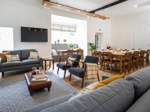 a living room with a couch and a dining room at Thorney How in Ambleside