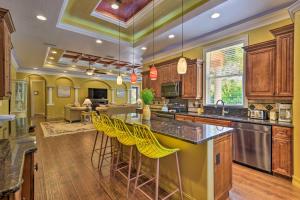 a kitchen with wooden cabinets and yellow bar stools at Elegant Venice Home with View - Walk to Beach! in Venice